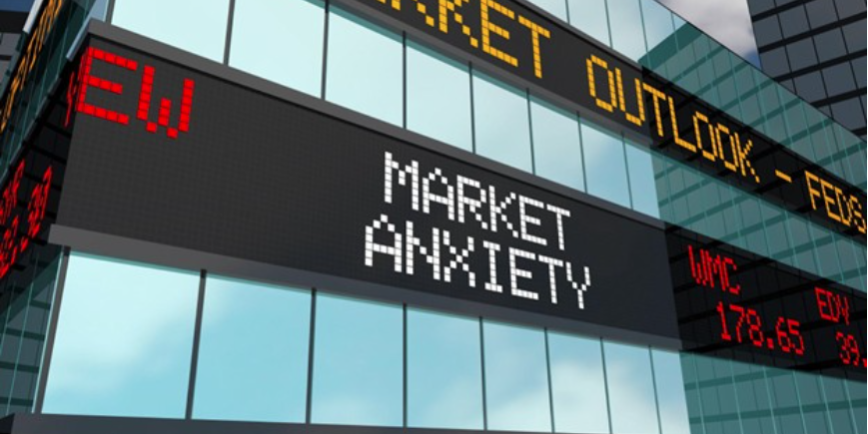 market A digital stock ticker display on a building showing 'Market Anxiety' and 'Market Outlook' in a city setting