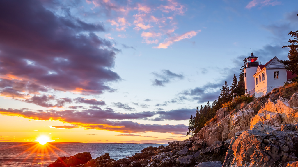 Core WM Lighthouse A scenic lighthouse standing on a rocky coast at sunset, symbolizing guidance and stability in financial planning